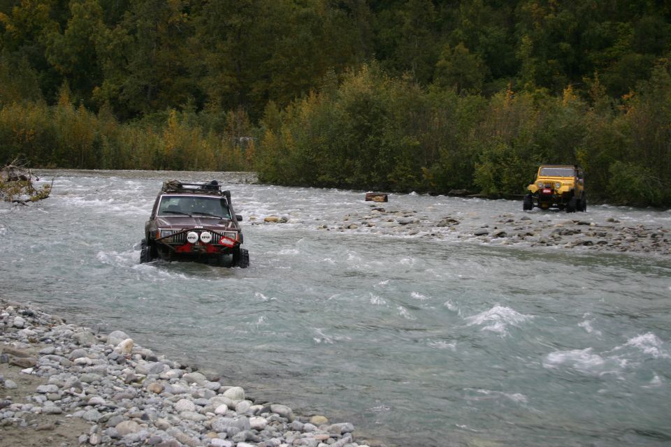 Brown Jeep TJ and yellow Jeep Wrangler driving through river, 2003