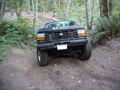 1992 Ford Ranger - This black 1992 Ford Ranger is shown tackling an off-road trail with "MUD ADDICT" emblazoned on its windshield.