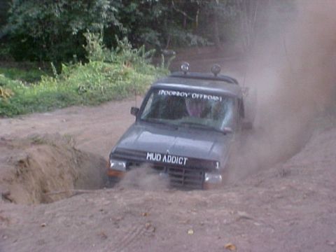 1992 Ford Ranger - A truck navigates a challenging muddy terrain, kicking up dust and dirt.