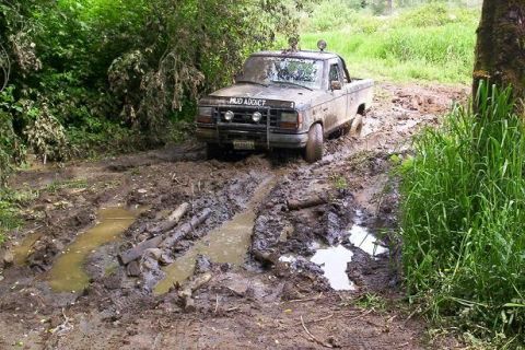 1992 Ford Ranger - This 1992 Ford Ranger is navigating a muddy off-road trail, with 'MUD ADDICT' visible on the hood.