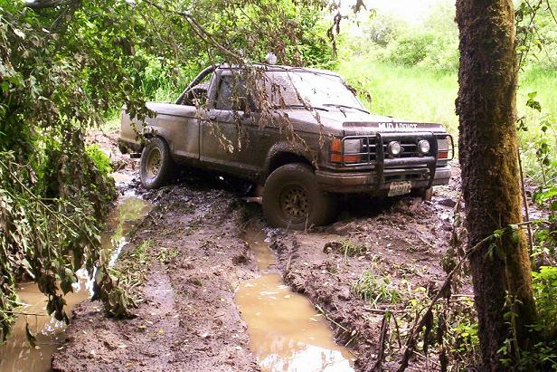 1992 Ford Ranger stuck in a muddy trail with trees and foliage around