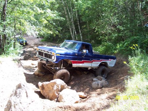 1977 Ford F-150 - This modified 1977 Ford F-150 navigates a challenging off-road course with a second vehicle visible in the background.