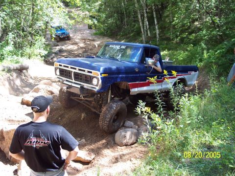 1977 Ford F-150 - 1977 Ford F-150 tackling an off-road course with other vehicles in the background.