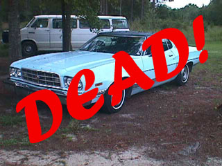 1994 Ford Crown Victoria - A light blue 1970s Ford sedan is shown with a large red 'DEAD!' overlay, parked outdoors with vans in the background.