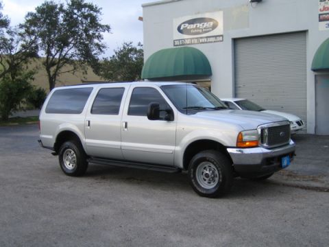 2000 Ford Excursion - A silver 2000 Ford Excursion is parked outside a commercial building with a "Panga Fishing Boats" sign.