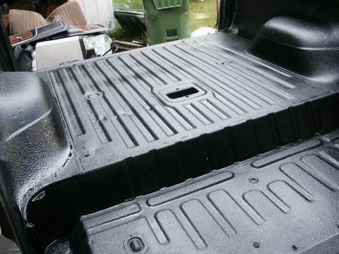 1982 Ford Bronco - The interior of a vehicle's cargo area has been coated with a textured black spray-in liner.