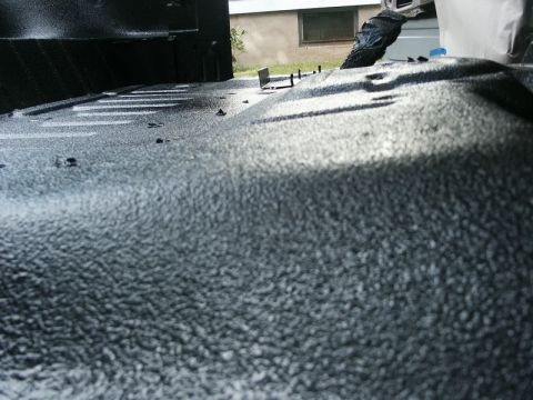 1982 Ford Bronco - The interior of a 1982 Ford Bronco shows a textured spray-in liner on the floor and lower walls.