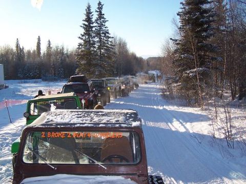 2003 Jeep TJ - Several Jeeps are seen on a snowy trail, with one Jeep in the foreground displaying orange lettering on its rear window.