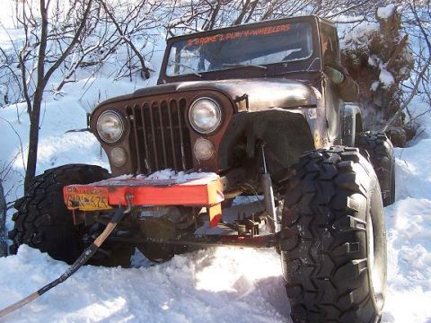 2003 Jeep TJ - Jeep CJ-7 stuck in snow, showing its front end and large tires.