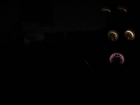 1985 Ford LTD Crown Victoria - Illuminated gauges are visible inside a vehicle's dark interior.