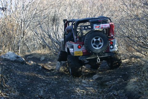 2003 Jeep TJ - Jeep TJ tackling a challenging rocky trail with its spare tire mounted externally.