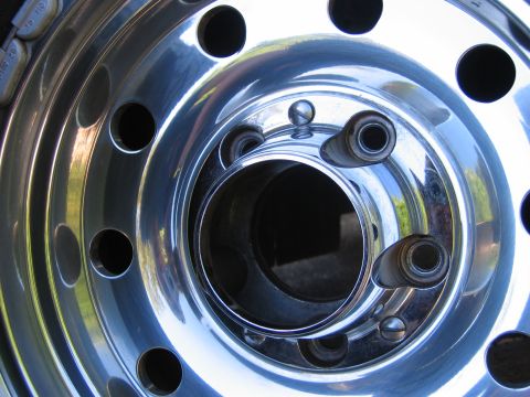 1995 Ford Bronco - A close-up view of a polished chrome wheel, showing its lug nut holes and reflective surface.