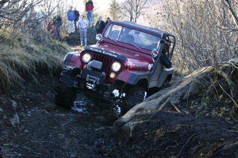 2003 Jeep TJ - Jeep TJ tackling a challenging rocky trail with onlookers present.