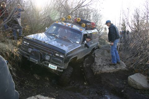 2003 Jeep TJ - A modified Chevrolet K5 Blazer navigates a challenging off-road course with onlookers present.