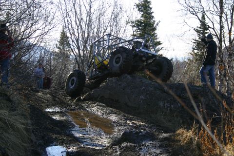 2003 Jeep TJ - A custom-built off-road vehicle navigates a challenging rocky and muddy terrain.