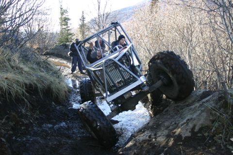 2003 Jeep TJ - A custom-built off-road buggy struggles on a challenging muddy and rocky incline.