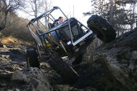 2003 Jeep TJ - Custom off-road buggy navigating a rocky incline on a trail.