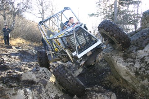 2003 Jeep TJ - A heavily modified off-road vehicle navigates a challenging rocky terrain.