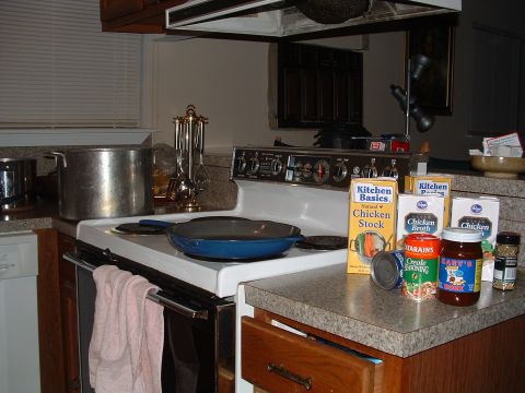 1993 Ford Bronco - A kitchen scene a stove with cookware and a collection of food items, including canned goods and jars.
