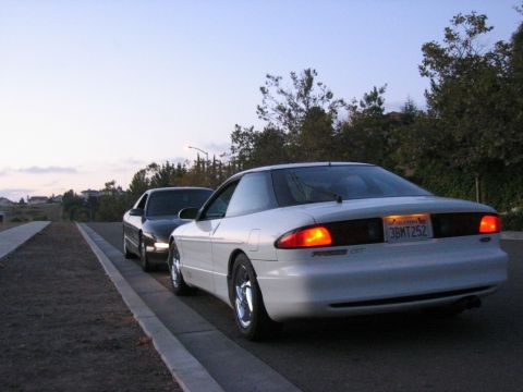 1997 Ford Probe - A white 1997 Ford Probe GT is parked on the side of the road, with another car behind it.