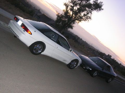 1997 Ford Probe - A white 1997 Ford Probe GT is parked next to a black coupe during sunset.