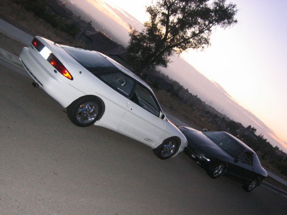 White 1997 Ford Probe GT parked with a black coupe behind it