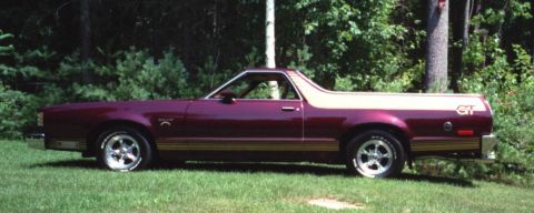 1972 Ford Ranchero - Maroon 1977 Ford Ranchero GT parked on grass with trees in background.