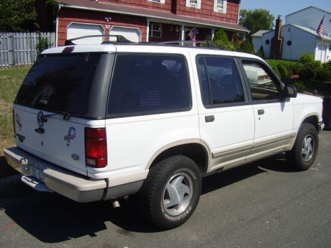 1991 Ford Explorer - This 1991 Ford Explorer is seen from the rear three-quarter angle, a white exterior and a camper shell.