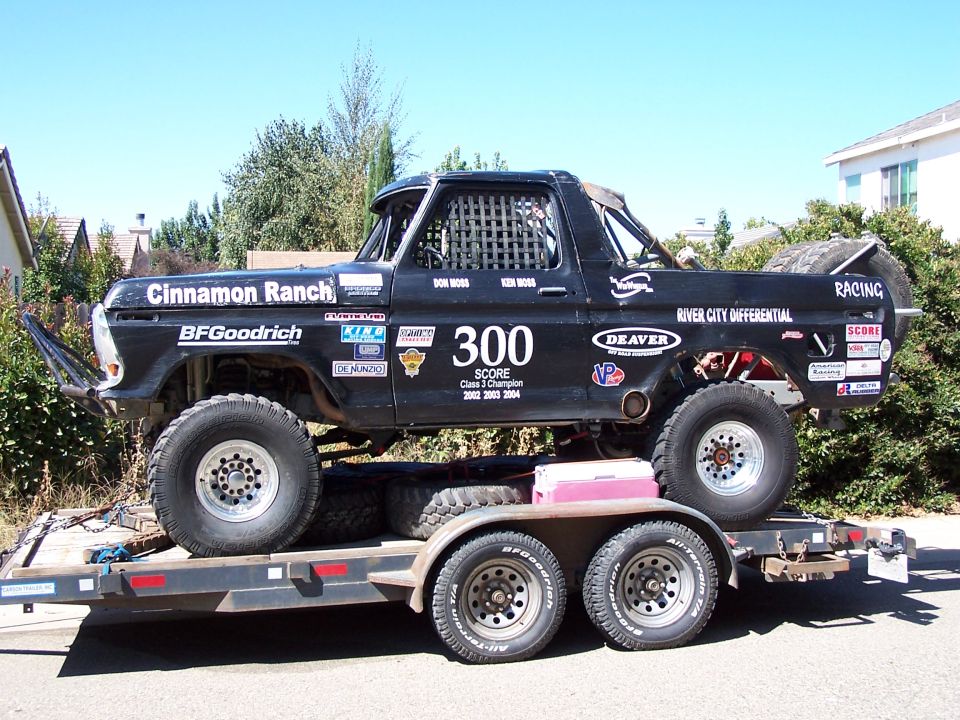 Black 1979 Ford Bronco race truck with "Cinnamon Ranch" and "BFGoodrich" decals, number 300, on a trailer