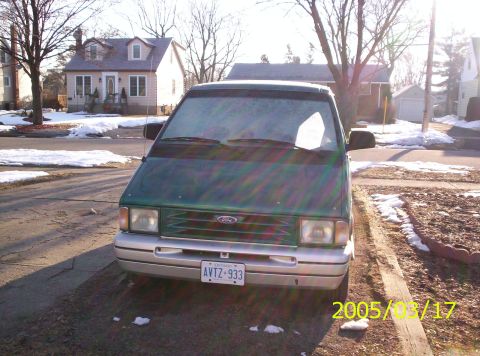 1994 Ford Aerostar - Front view of a green 1994 Ford Aerostar van, parked on a street with houses in the background.