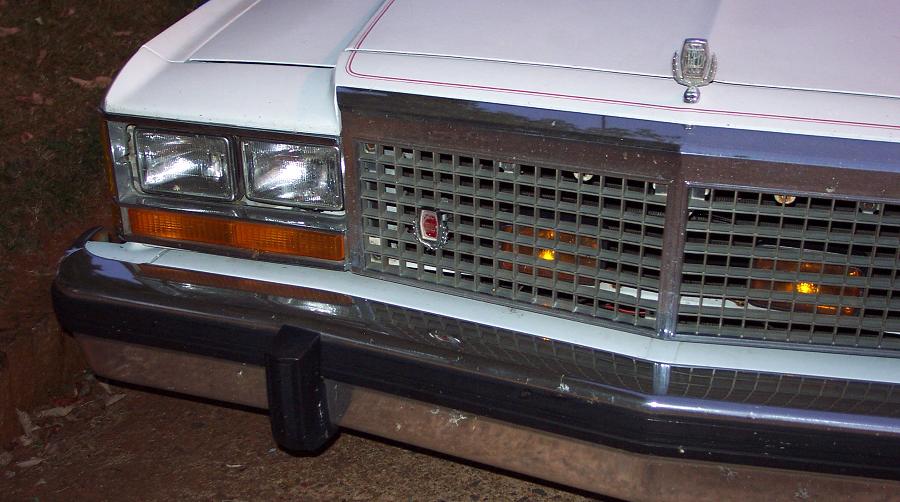 front grille and headlights of a white 1980s Ford Crown Victoria