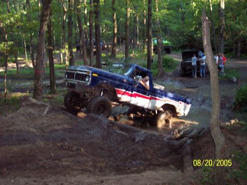 1977 Ford F-150 - This lifted pickup truck navigates a muddy obstacle course in a wooded area.