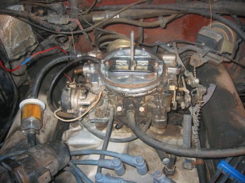 1978 Ford Bronco - Close-up view of an engine's carburetor and associated fuel and ignition components.