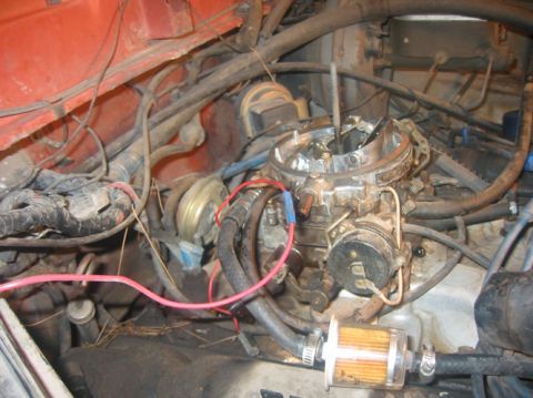 1978 Ford Bronco - Close-up view of an engine bay, focusing on the carburetor and fuel filter assembly.