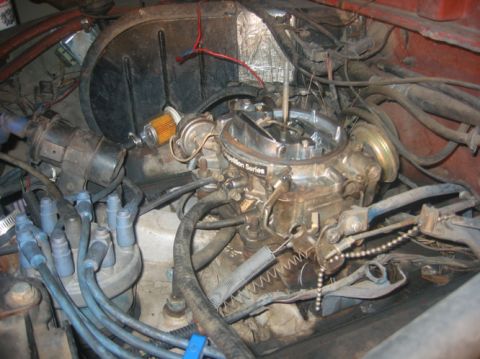 1978 Ford Bronco - Close-up of a vehicle's engine bay, focusing on the carburetor and associated components.