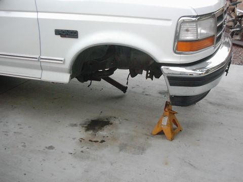 1978 Ford Bronco - This white Ford Bronco is on jack stands, revealing its front suspension and a chrome bumper.