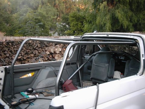 1978 Ford Bronco - Interior view of a white SUV with a custom roll cage, showing the seats and dashboard area.