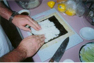 1993 Ford Bronco - A close-up view of hands meticulously preparing food on a cutting board, with ingredients and kitchen items visible.