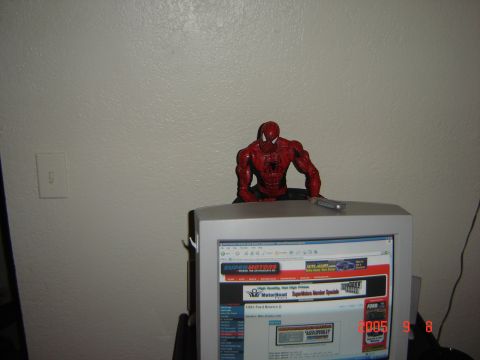 1993 Ford Bronco - A Spider-Man figurine sits atop a computer monitor displaying a listing for a 1993 Ford Bronco II.
