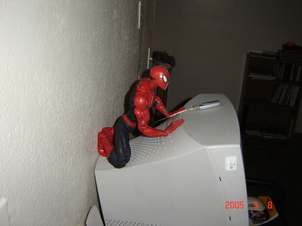 Spiderman action figure posed on top of a beige computer monitor