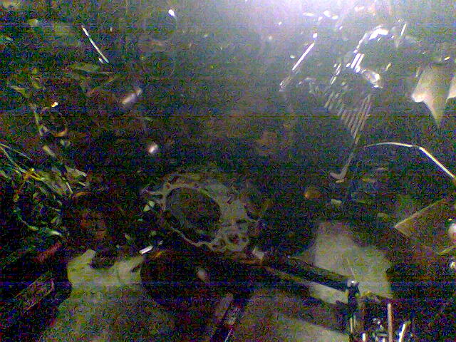 Dark grainy photo of an engine block rear showing bellhousing bolt flange