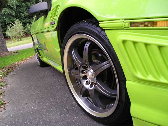 Lime green 1984 Pontiac Fiero side view with custom wheels and body kit