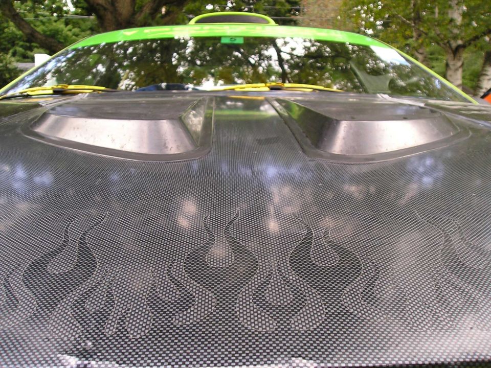 Car hood with carbon fiber wrap and flame graphics, green trim on windshield, two air vents