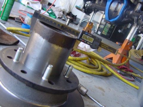 1971 Ford Bronco - Digital caliper measures a vehicle hub and brake rotor assembly in a workshop setting.