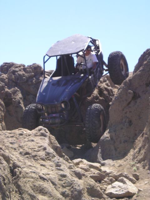 1989 Ford Bronco - Buggy navigating a rocky trail under a clear blue sky.