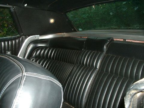 1968 Ford Thunderbird - Interior view of the rear seats in a 1968 Ford Thunderbird, showing the black vinyl and stitching details.