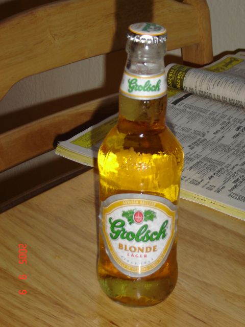 1993 Ford Bronco - A bottle of Grolsch Blonde Lager sits on a wooden surface next to a newspaper.