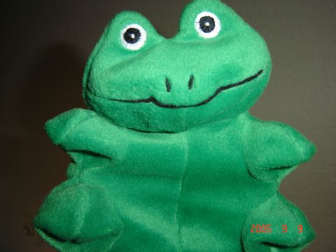 1993 Ford Bronco - A close-up of a green plush frog toy, its characteristic wide smile and large, round eyes.