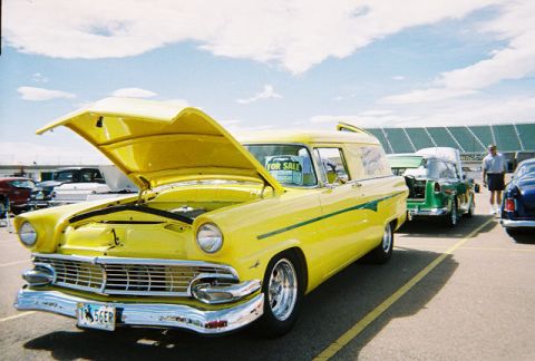1972 Ford Ranchero - A yellow 1956 Ford sedan delivery is parked with its hood up, displaying a "FOR SALE" sign.