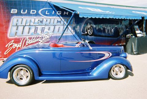 1972 Ford Ranchero - Custom blue hot rod convertible with red interior and graphics is displayed at an event.